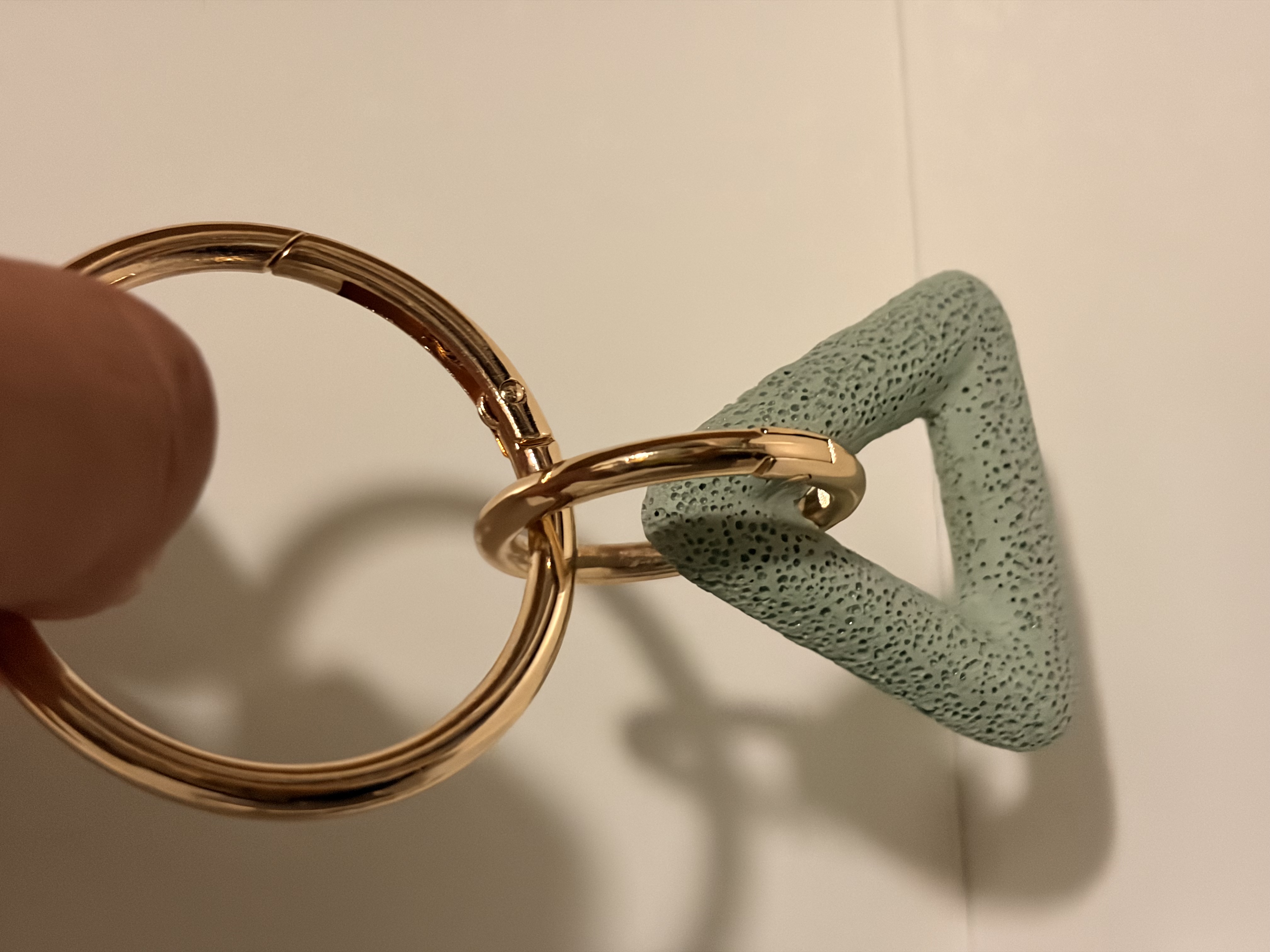 Mine Triángulo Mint Green en mano con aros Oro Sereno